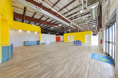 Storage Star rental office featuring yellow walls, blue cabinets, high ceilings, and exposed metal ventilation ducts