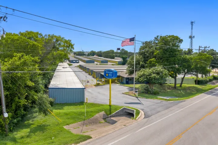 Aerial view of a Storage Star facility with drive-up units, gated entrance, and a tall American flag