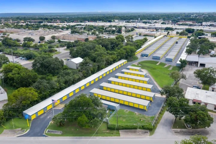 Aerial view of a self-storage facility with yellow unit doors, drive-up access, and a flagpole